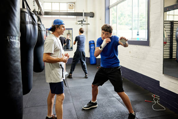 istock Mature coach working with teenage shadow boxer 2205044746
