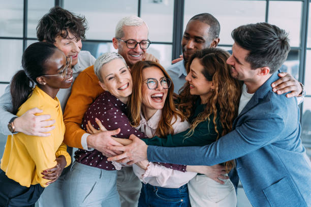 Excited coworkers embracing each other during a celebration in the office.