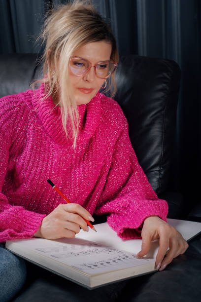 istock Woman composer writing music notes on a notebook with a pencil 2205053414