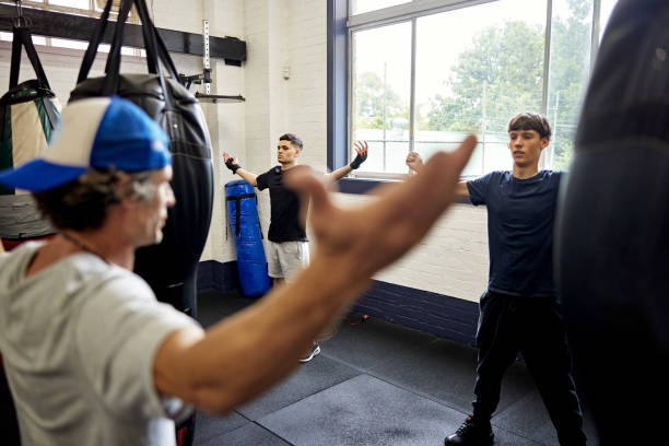 Trainer and teenage boxers warming up with arm circles