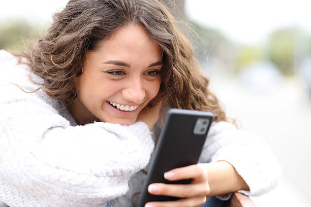 istock Happy woman enjoying using mobile phone 2205054311