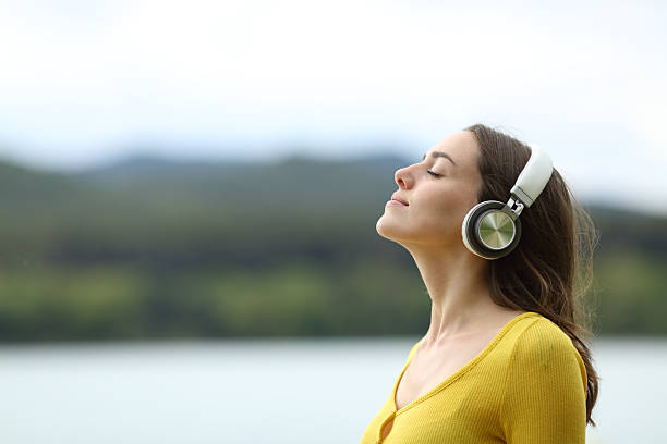istock Woman meditating listening audio guide online 2205054424