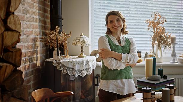 A selfassured woman stands confidently in a stylish and inviting room that is filled with natural decor and beauty