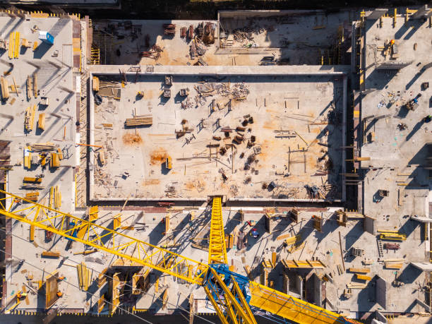 istock Construction site showcases vibrant materials and equipment under bright sunlight in an urban area. Aerial top down view 2205057878