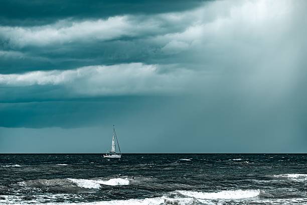 istock Sailboat on choppy sea under dramatic sky. 2205058015