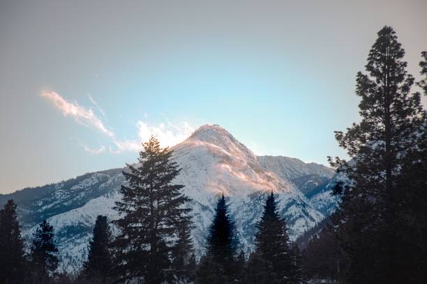 istock Stunning mountain landscape with snow-capped peaks and pine trees under a clear blue sky 2205059182