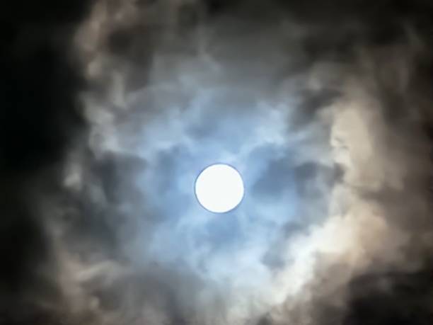 istock The full moon lights up the night through the gaps in the dark clouds, creating a dramatic and mysterious scene. Its glow pierces the air’s moisture, transforming the nocturnal landscape into a canvas of silvery light. 2205059403
