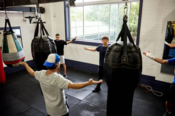 istock Coach leading young boxers in warm up exercise for shoulders 2205060459