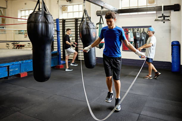 Young fighters in training with coach at boxing club