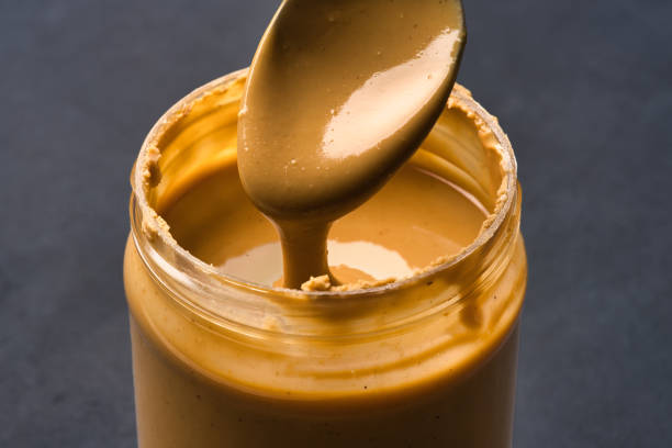 Delicious and healthy peanut butter on black background