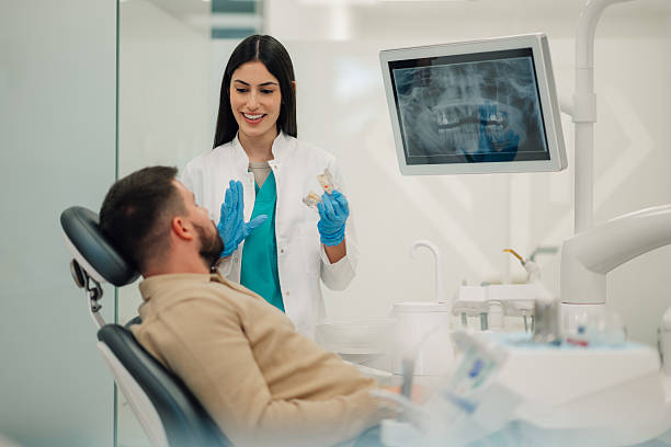istock Dentist showing teeth x-ray to patient in modern clinic 2205072439