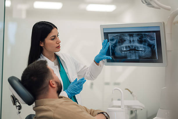 istock Dentist showing teeth x-ray to patient in modern clinic 2205072447
