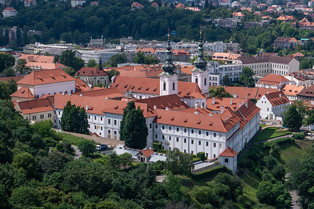 istock Panoramic view of Prague with the Vltava River, historic bridges, and red rooftops, surrounded by lush greenery. Stunning European cityscape showcasing Czech Republic’s architectural and natural beaut 2205073399