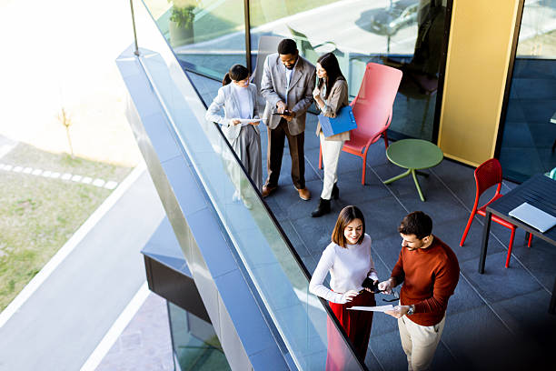 istock Colleagues engage in a productive discussion on a modern office balcony during a sunny afternoon 2205073776