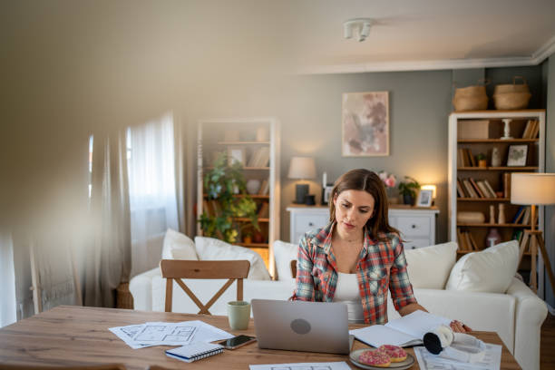 istock Focused architect working remotely on laptop at home 2205074612