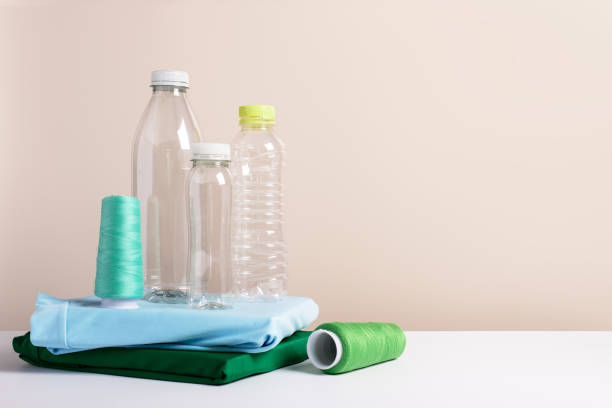 istock Plastic bottles and folded t-shirts, copy space, concept of clothes made from recycled plastic bottles 2205077702