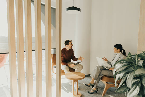 istock Engaging conversation unfolds inside a modern, stylish lounge with natural light filtering through 2205078697