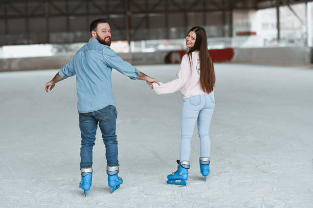 Young couple in love have fun, active date ice skating on the ice arena on a winter day,legs close-up.Winter entertainment,leisure activity,Valentine's day.