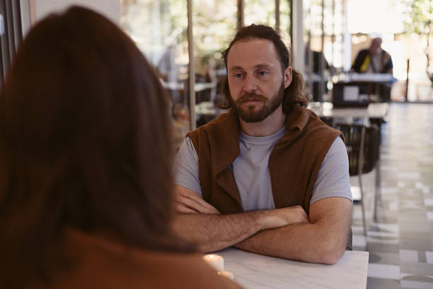 istock Man with beard engages in conversation at cafe on a sunny day 2205080408