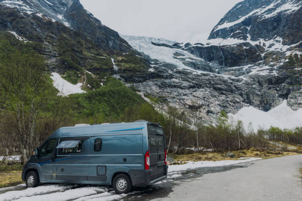 Motor Home parking by the rural road with background view of crystal blue glacier in Western Norway, Scandinavia