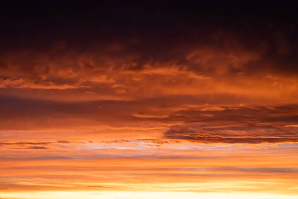 istock Vibrant sunrise sky with orange and red clouds 2205083433