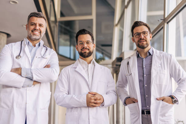 istock Three confident doctors smiling in hospital corridor 2205089379