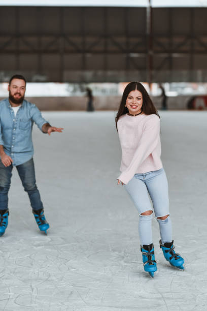 istock Friends Having Fun Competing in Ice Skating Race and Smiling 2205090031