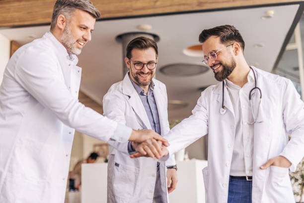 istock Doctors joining hands, showing support and teamwork in hospital 2205090338