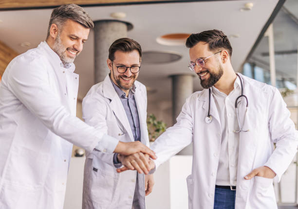 istock Doctors joining hands, showing support and teamwork in hospital 2205090340