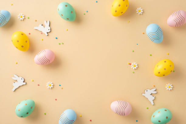 istock Colorful Easter eggs, bunnies, daisies, and confetti adorning a beige background 2205091817
