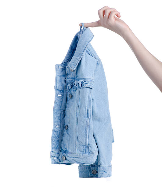 istock Female hand holding denim jacket 2205091907