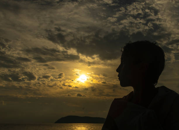istock Silhouette of a child at sunset on the beach 2205092070