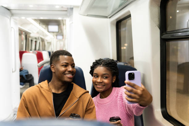 istock Young couple taking a selfie on the train while drinking coffee 2205092333