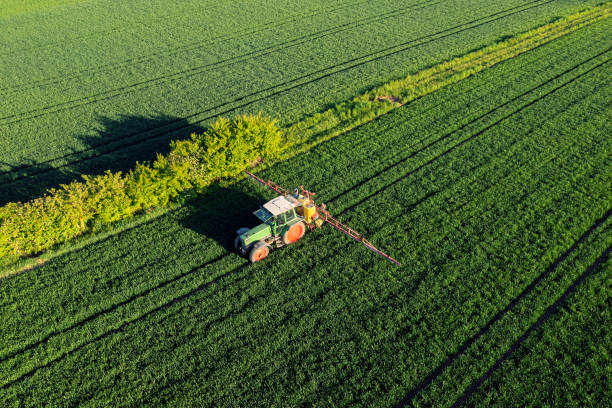 istock Agricultural tractor spraying field 2205093141
