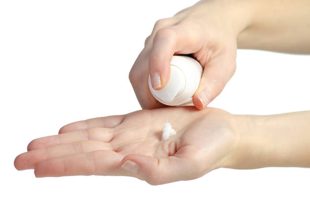 istock Woman pouring lotion into hand on white background isolation. 2205093216