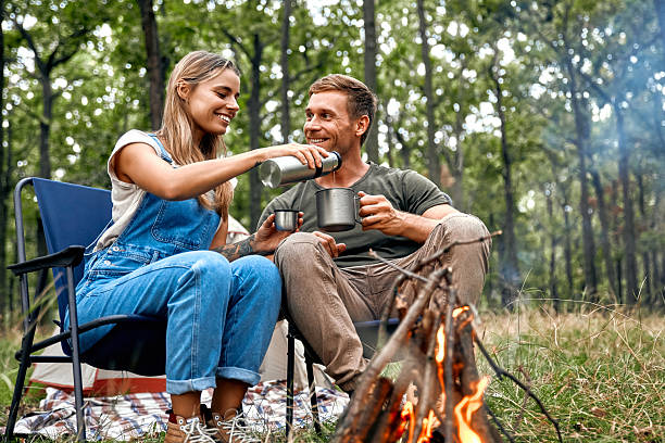 istock A Couple Enjoying Their Coffee by a Warm Campfire Surrounded by Beautiful Nature 2205094487