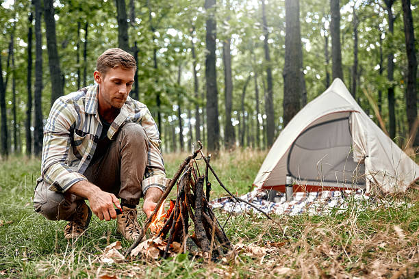 istock A Solo Camper is Diligently Preparing a Cozy Campfire in a Beautifully Serene Forest Setting 2205094573