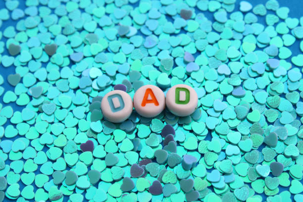 Word DAD on a background filled with colorful hearts