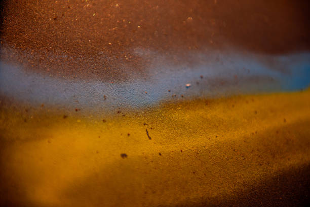 Close-up of a textured surface featuring blue and yellow spray paint blending together, creating an abstract and artistic effect with scattered particles. Ukraine flag
