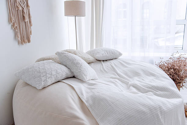 istock Comfortable interior design featuring white pillows and blanket on beanbag chair 2205098237