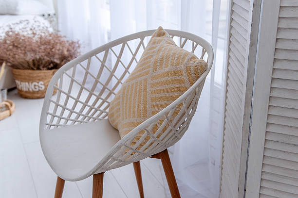 istock Modern white chair with yellow cushion illuminating bright interior design 2205098742