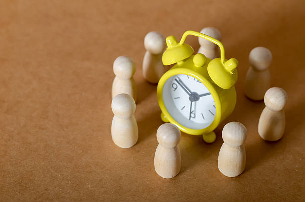 istock Time Management and Teamwork Concept with Wooden Figures and Alarm Clock 2205099045