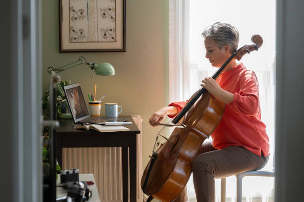 istock Woman Watching A Tutorial On Laptop On How To Play Cello 2205099680