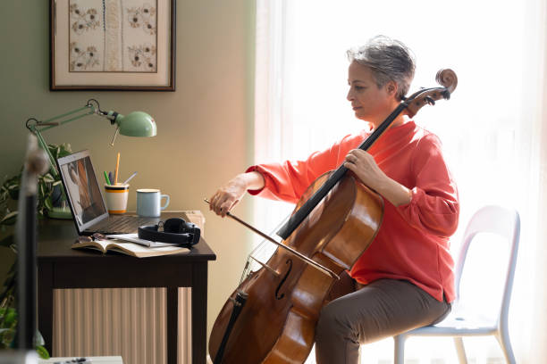 istock Woman Watching A Tutorial On Laptop On How To Play Cello 2205099741
