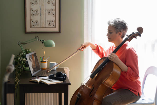 istock Woman Watching A Tutorial On Laptop On How To Play Cello 2205099871