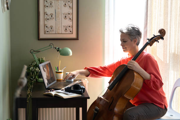 istock Woman Watching A Tutorial On Laptop On How To Play Cello 2205099902