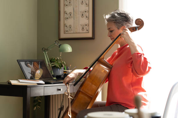 istock Woman Watching A Tutorial On Laptop On How To Play Cello 2205100814
