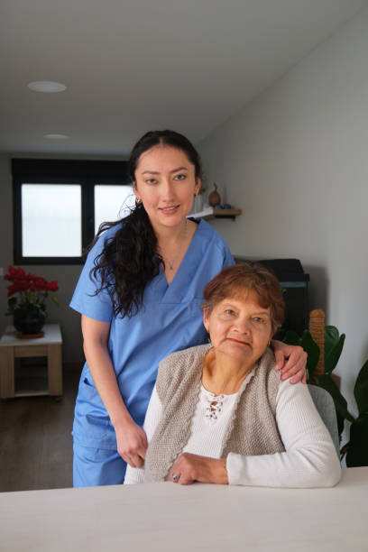 istock Young nurse assisting elderly woman at home 2205103762