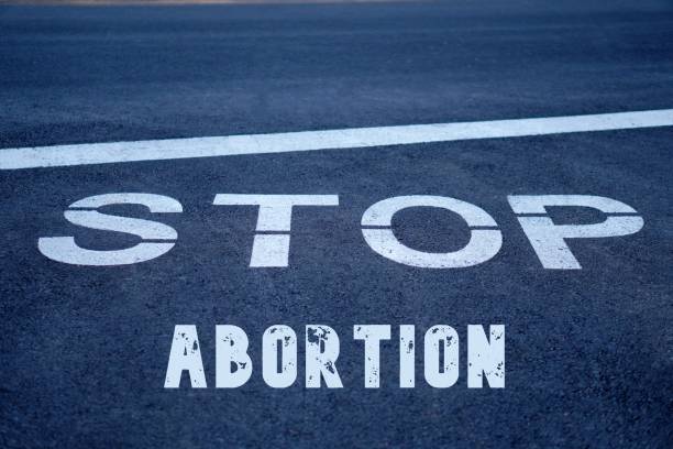 istock stop abortion. words written on the asphalt on a road sign 2205103903
