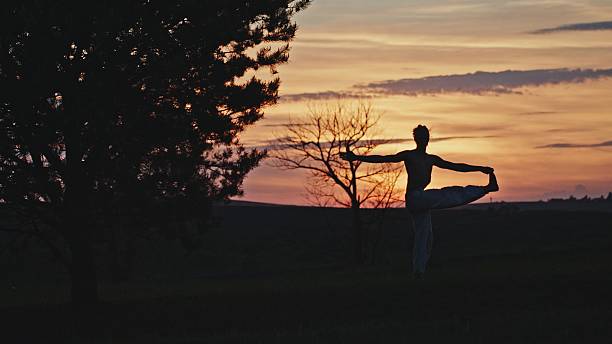 A graceful dancer showcases elegance against a stunning sunset, embodying tranquility, peace, and beauty